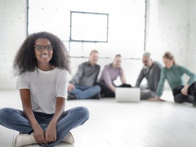 Group Of People Sitting On The Floor With Focus On Woman in White Crew Neck T-shirt