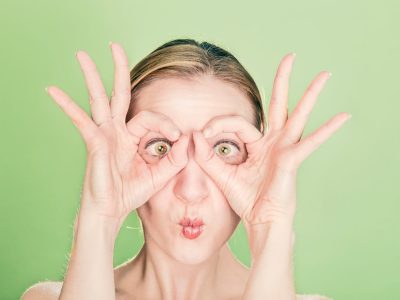 Woman Doing Goggles Hands Gesture.