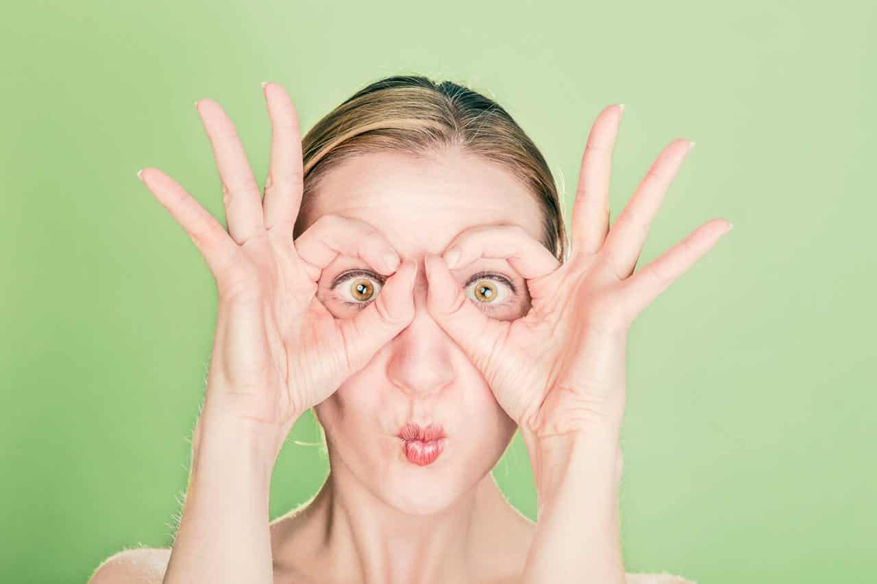 Woman Doing Goggles Hands Gesture.