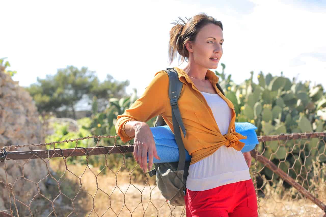 Woman Leaning on Cyclone Fence.